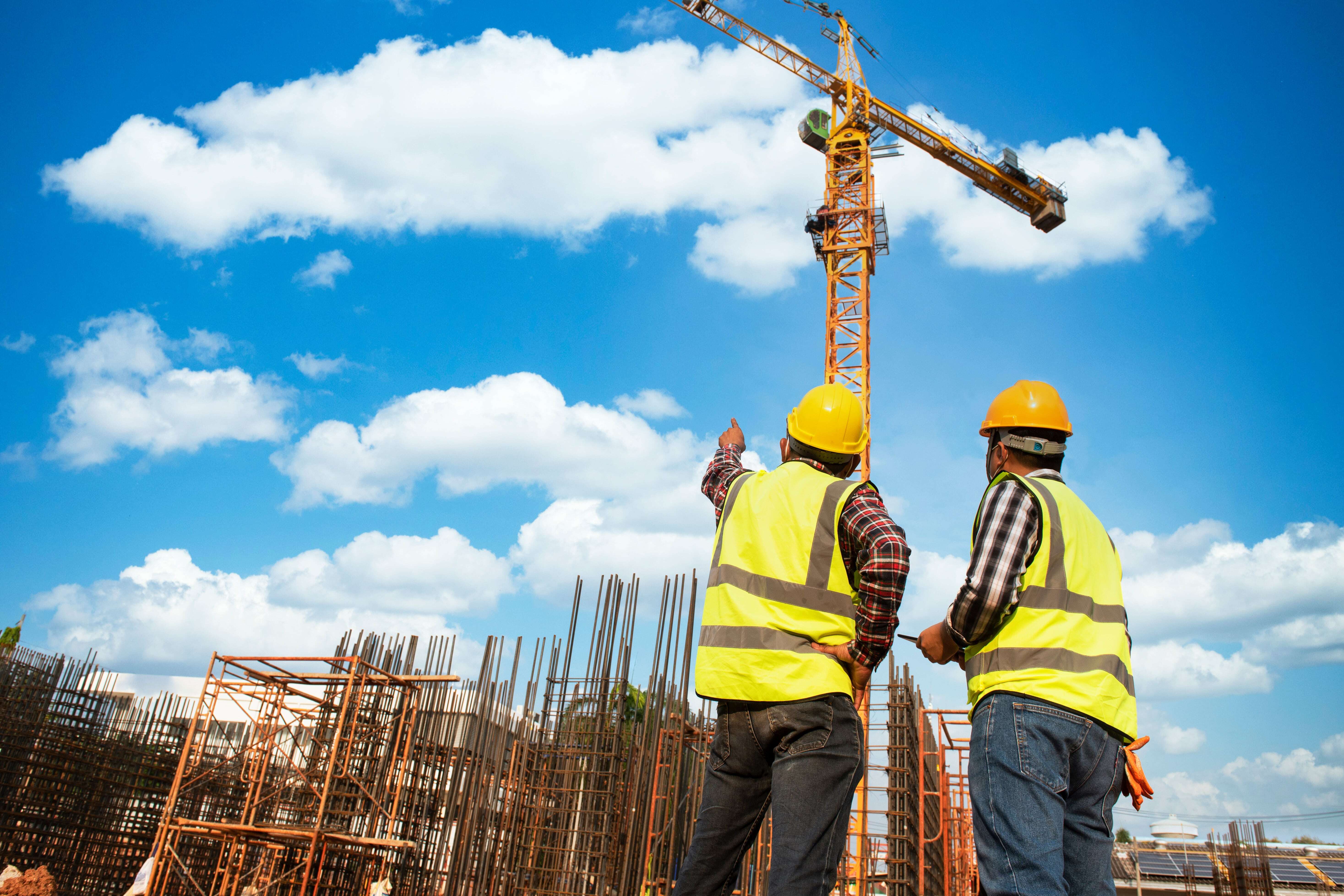 two contstruction workers planning industrial building